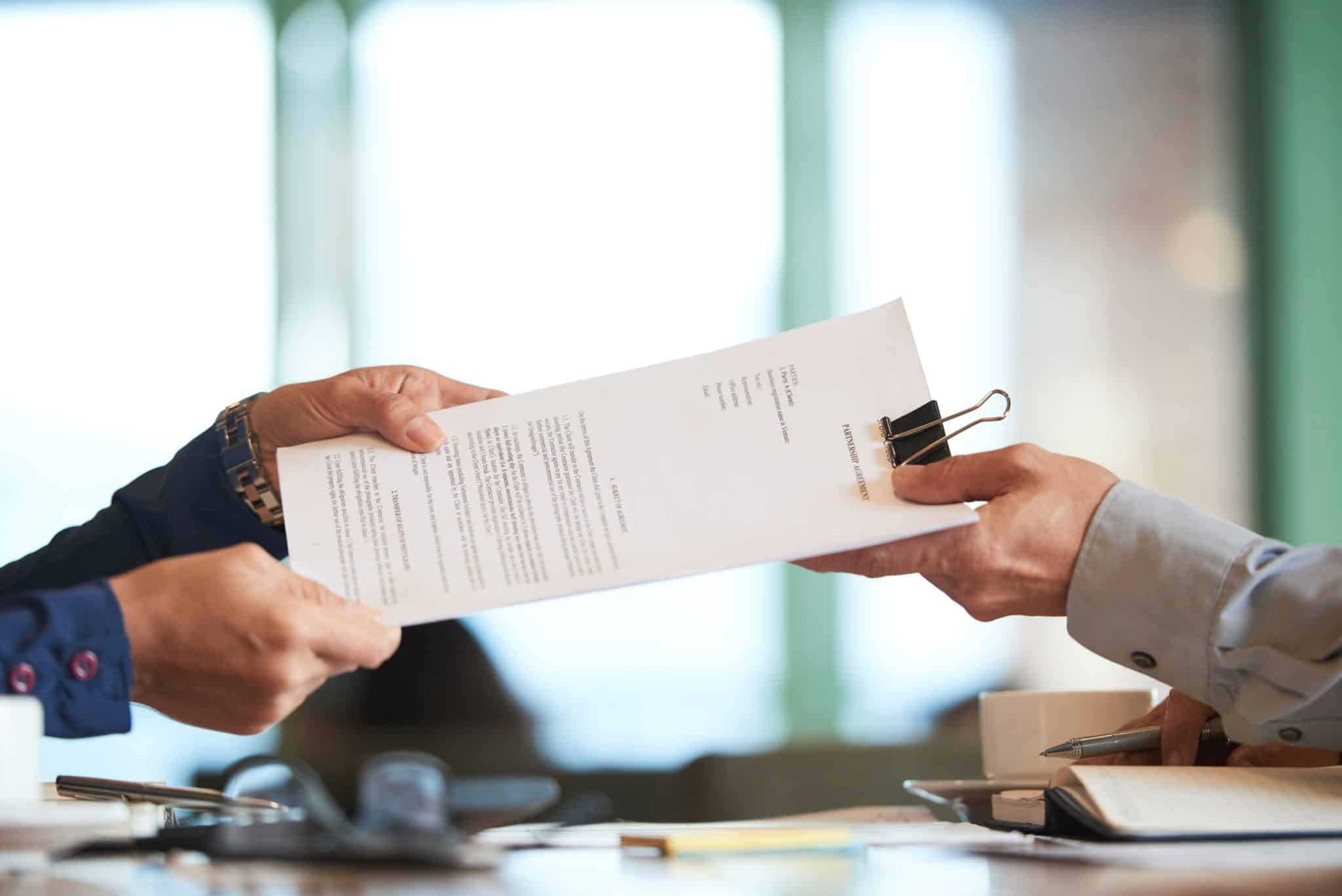 Des mains se tendant un contrat signé